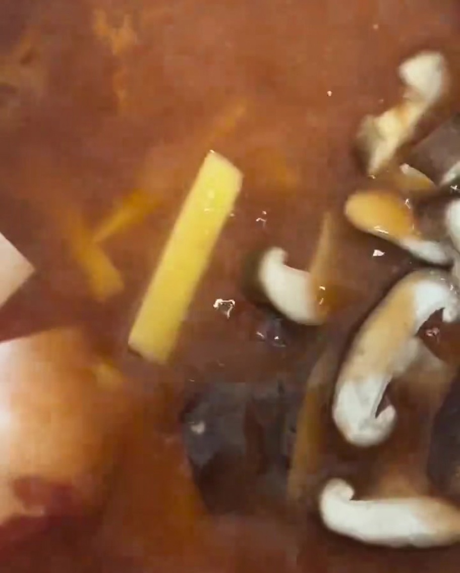 찌개에 표고버섯 슬라이스를 넣는 모습.