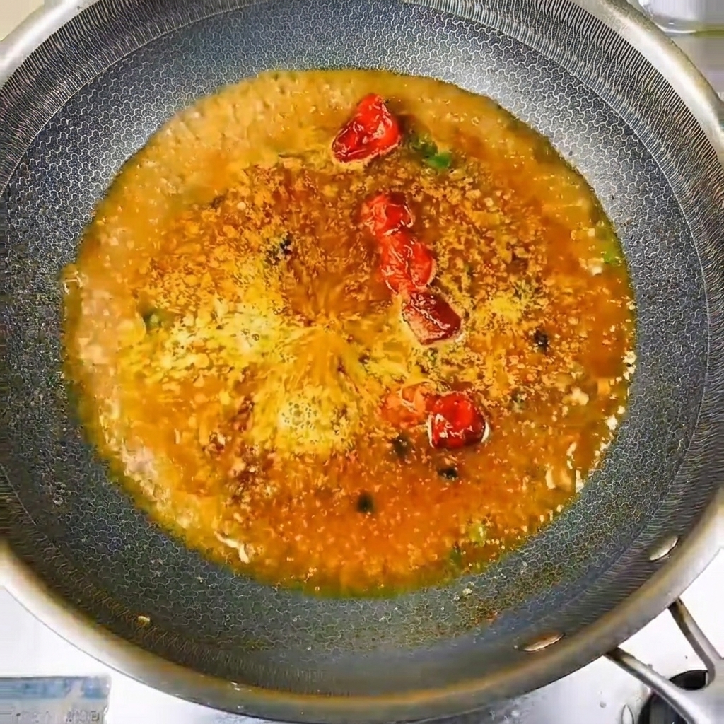 끓는 육수에 작은 민물고기를 동그랗게 둘러 담는 모습.