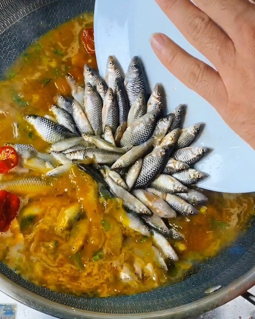 배치된 생선 위로 요리용 술과 식초를 뿌리는 모습.