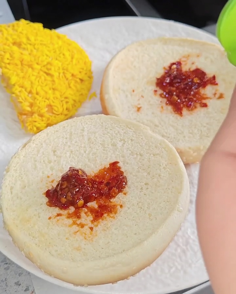 접시 위에 양상추, 치킨 필렛 두 장, 치즈, 토마토 순으로 쌓아 완성된 버거 모습.