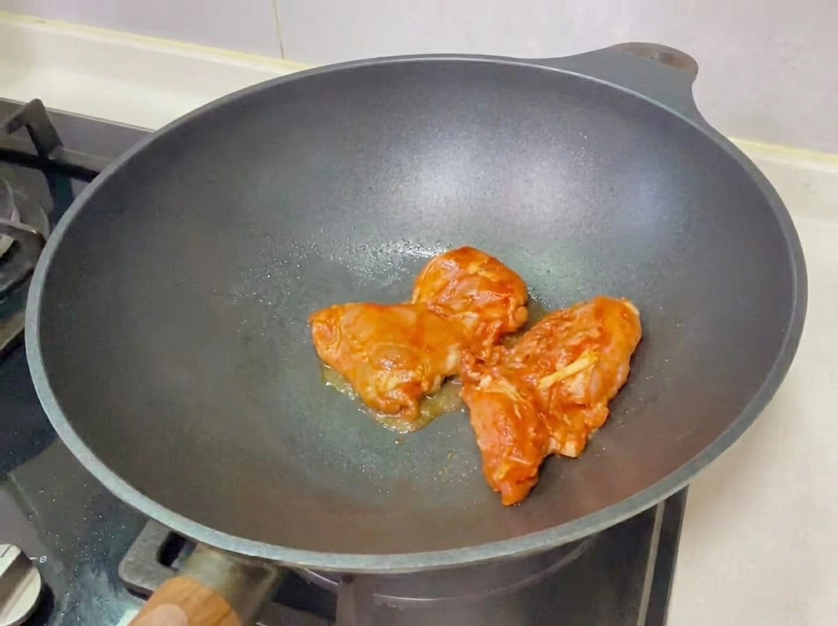 완성된 데리야끼 치킨 버거가 도마 위에 놓인 모습.