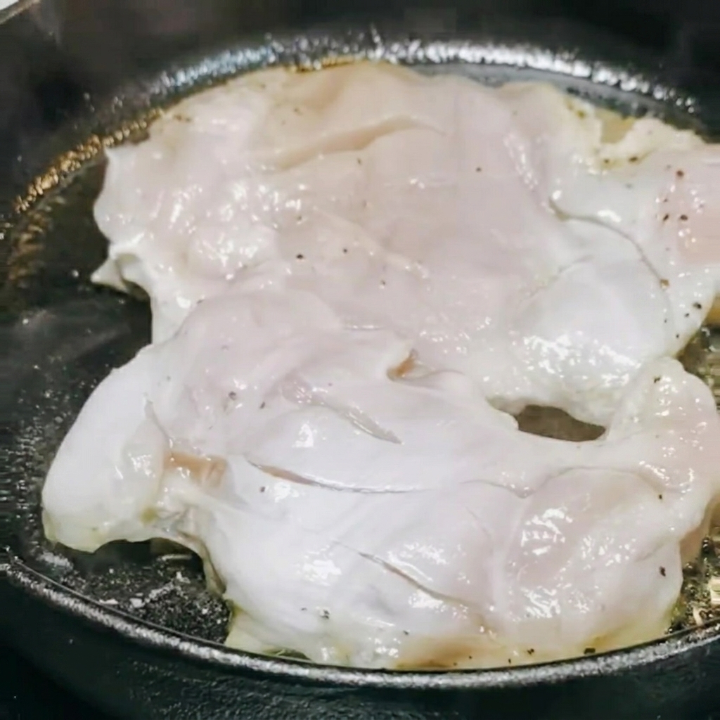 팬 안에서 닭고기에 데리야끼 소스와 화이트 와인을 부어 졸이는 모습.