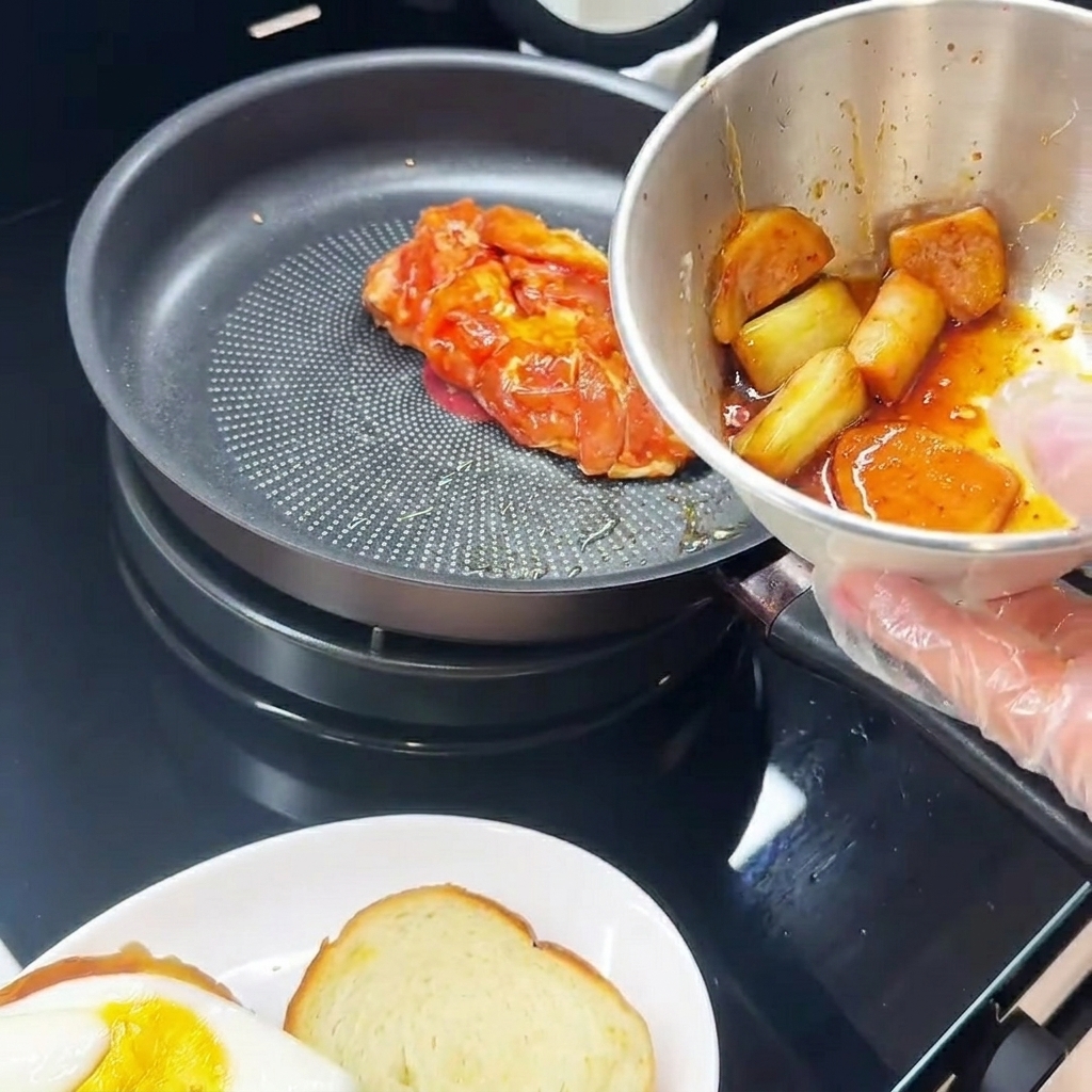 양념한 닭다리살을 껍질 면부터 팬에 올려 굽는 모습.