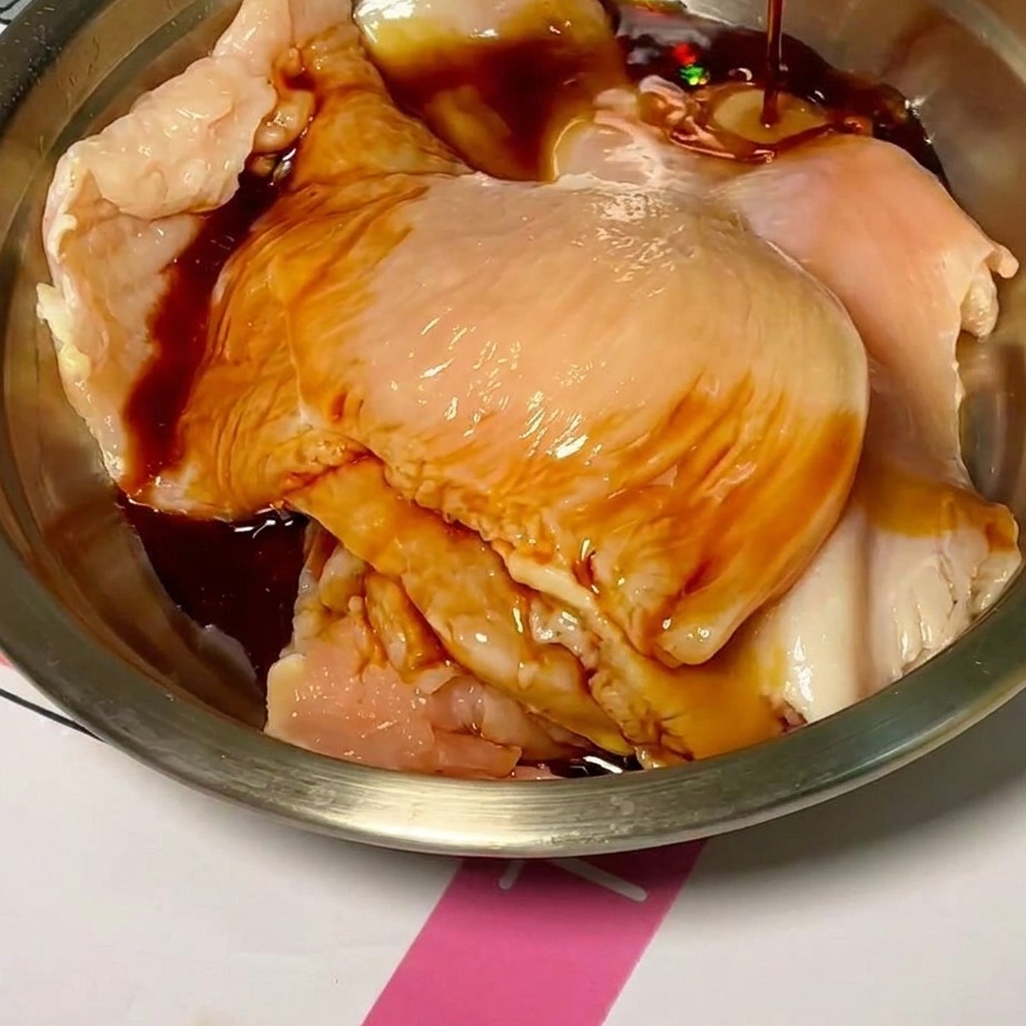 볼에 담긴 닭고기가 소스에 버무려지는 모습.