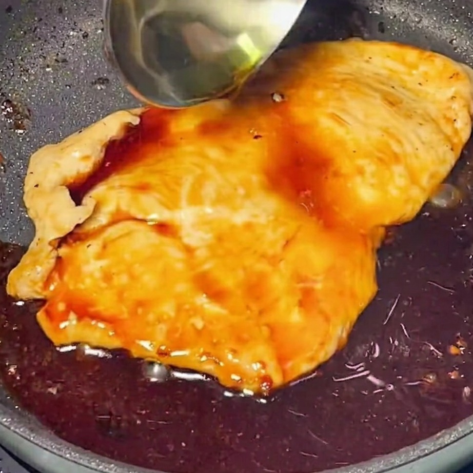 노릇하게 익은 치킨 위에 반짝이는 데리야끼 소스를 붓는 모습.