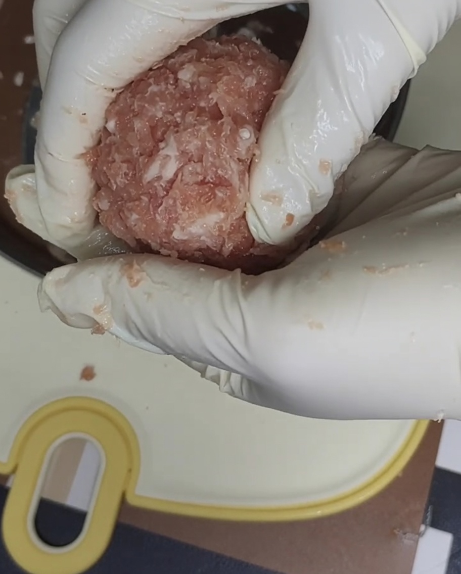 몰드와 랩을 사용하여 돼지고기를 패티 모양으로 만드는 모습.