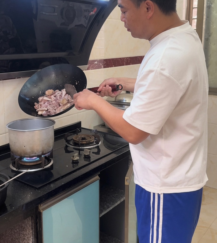볶은 닭고기와 생강을 끓는 물이 담긴 큰 냄비에 붓는 모습.