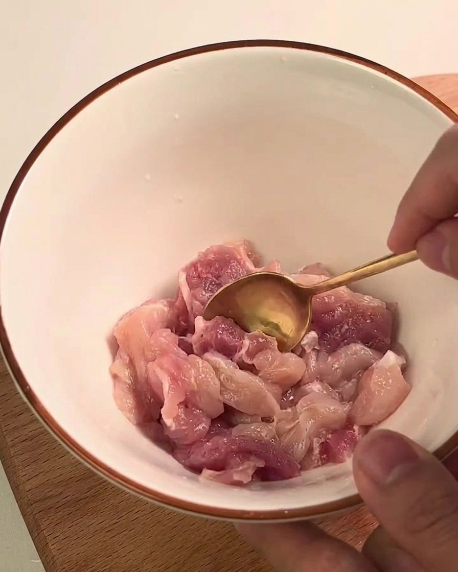 유리 계량컵 안에서 포크로 부드럽게 익은 단호박을 으깨는 모습
