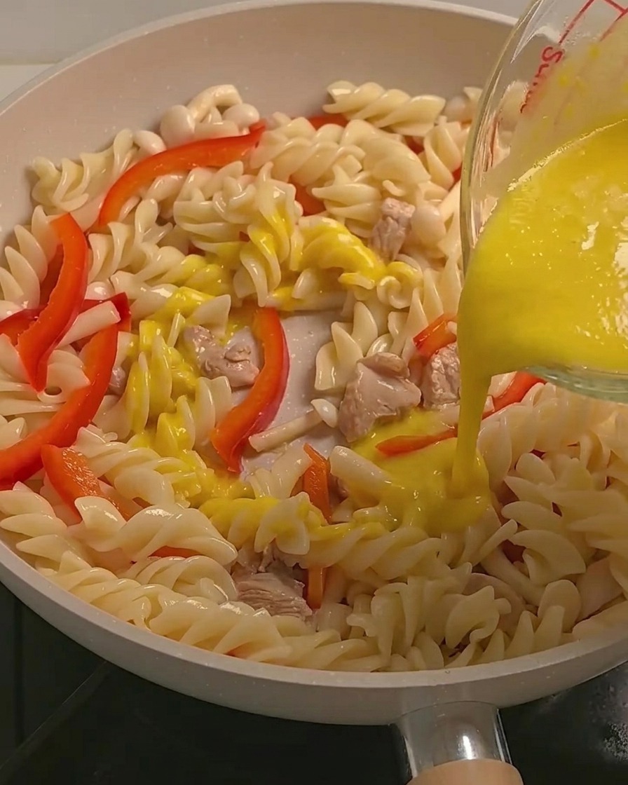 파스타와 닭고기, 채소 위에 노란 단호박 크림 소스를 붓는 모습