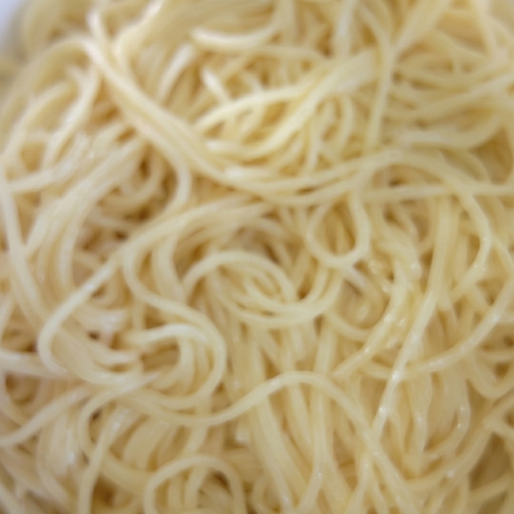 삶아진 스파게티 면을 그릇에 담아 오일과 버무리는 모습.