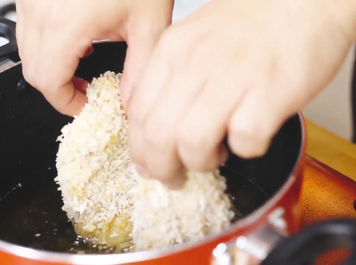 달궈진 기름에 빵가루 입힌 치킨을 넣고 튀기는 모습.