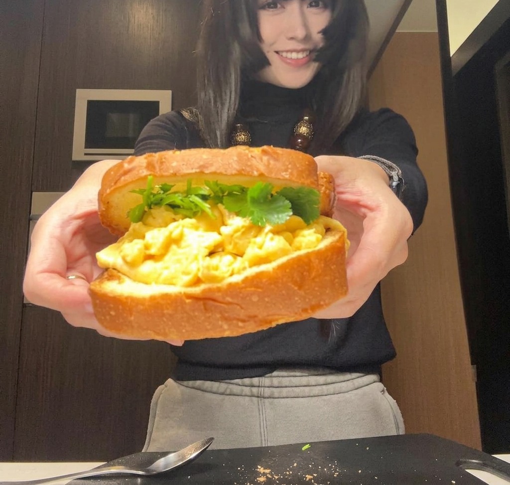 완성된 샌드위치를 양손으로 잡고 포장하거나 자르기 직전의 모습
