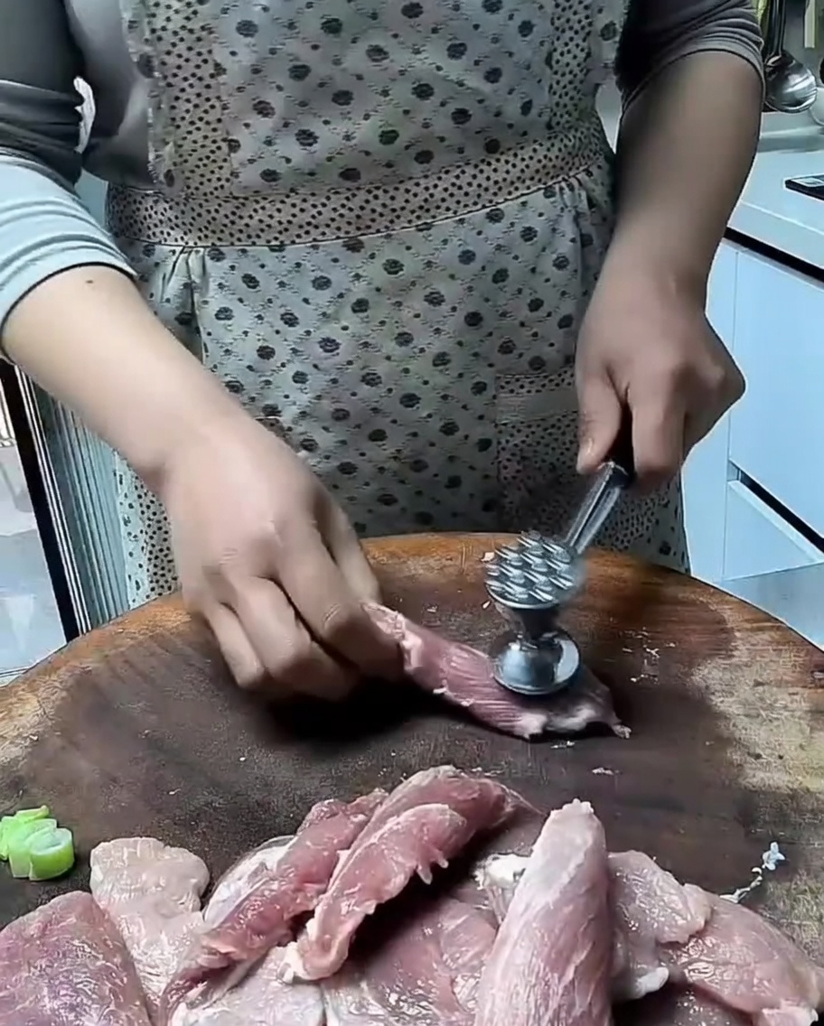 고기 망치로 돼지고기 슬라이스를 두드리는 모습.