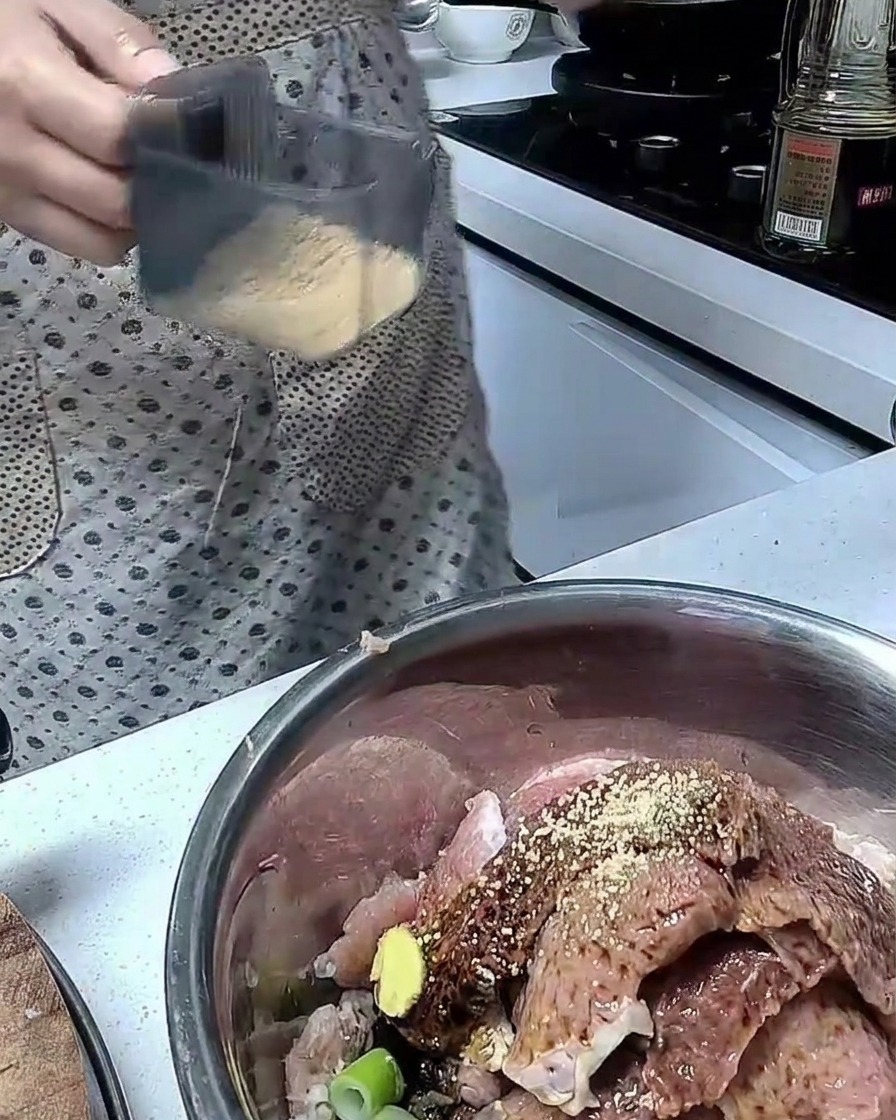 스테인리스 볼에 돼지고기와 각종 양념을 넣고 섞는 모습.