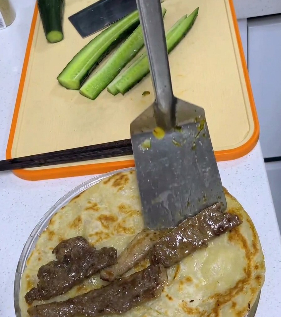 노릇하게 구운 파전 중앙에 익힌 돼지고기를 올린 모습.
