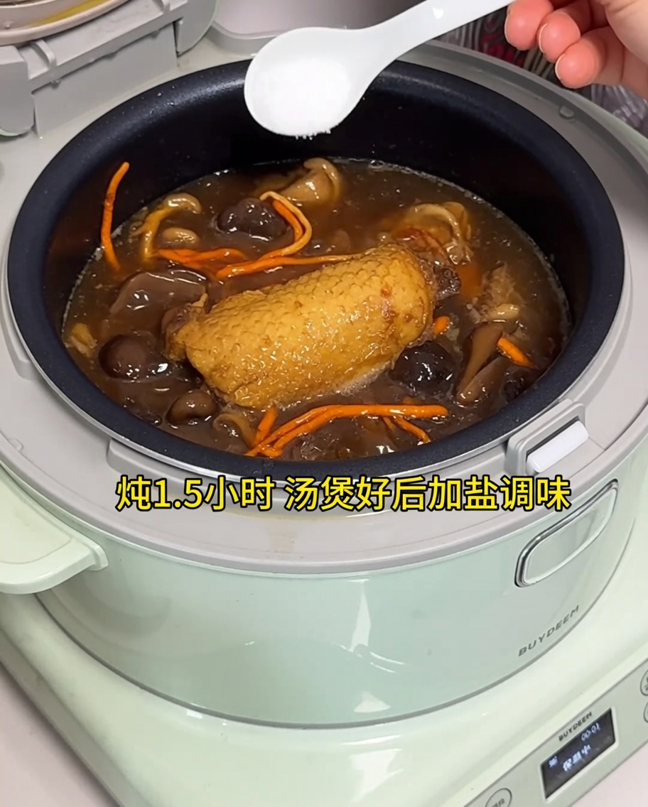 전기밥솥에 완성된 닭고기 국물에 소금을 넣는 모습.