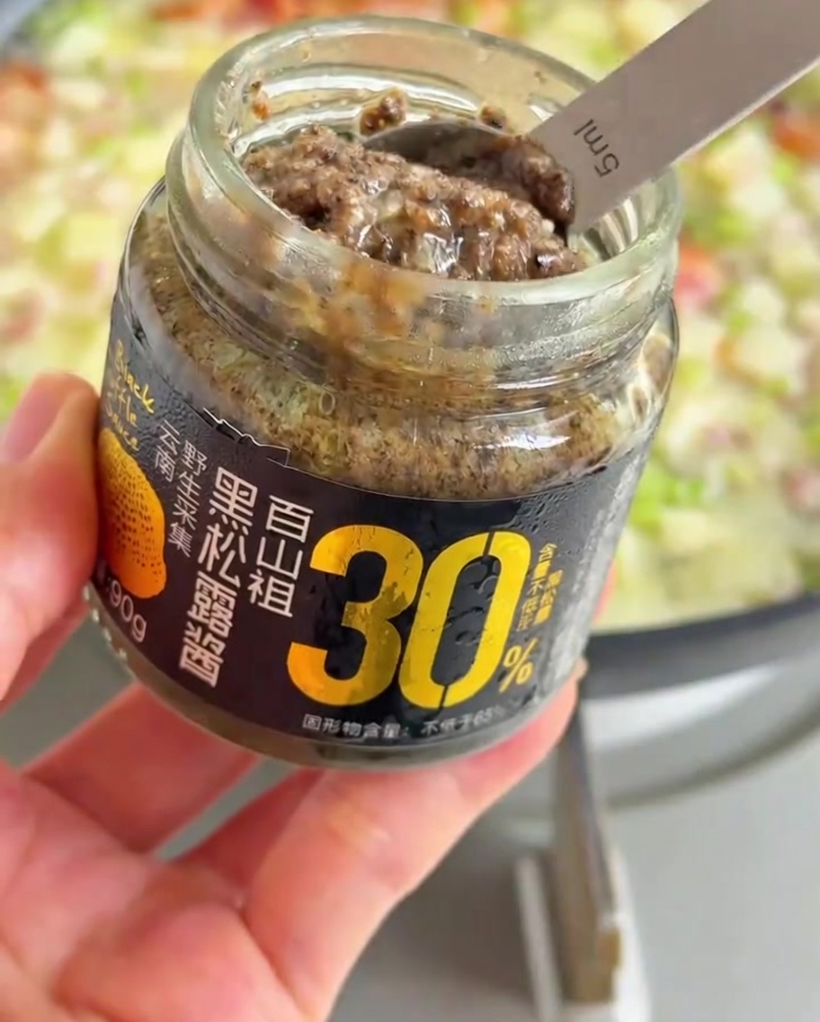 수프에 블랙 트러플 페이스트를 한 숟가락 넣는 모습.