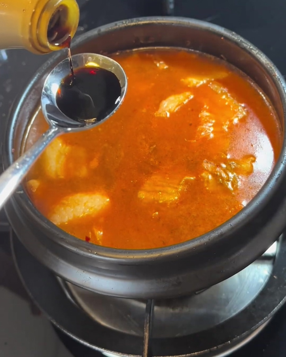 끓는 찌개에 간장을 넣는 모습.