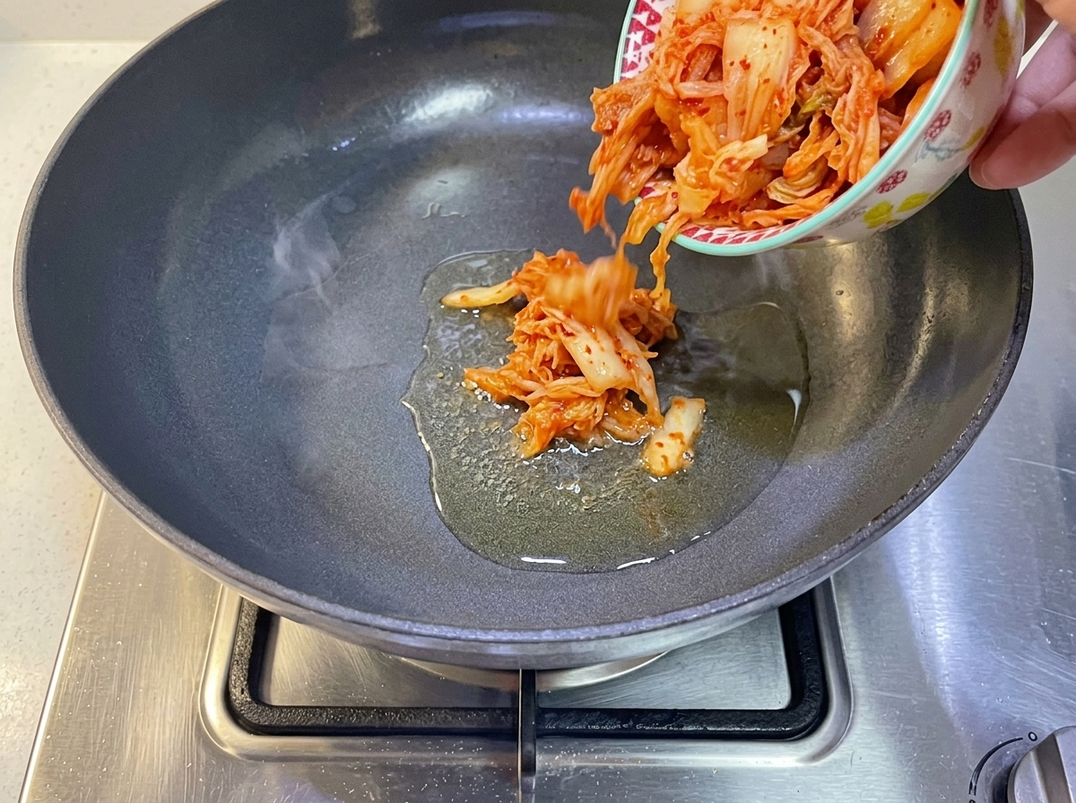 기름을 두른 달궈진 팬에 묵은지를 넣는 모습.