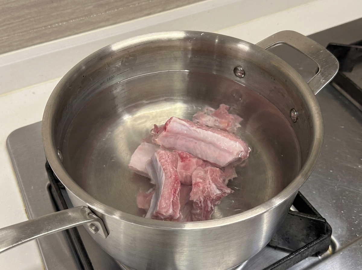 찬물이 담긴 스테인리스 냄비에 담긴 생돼지갈비.