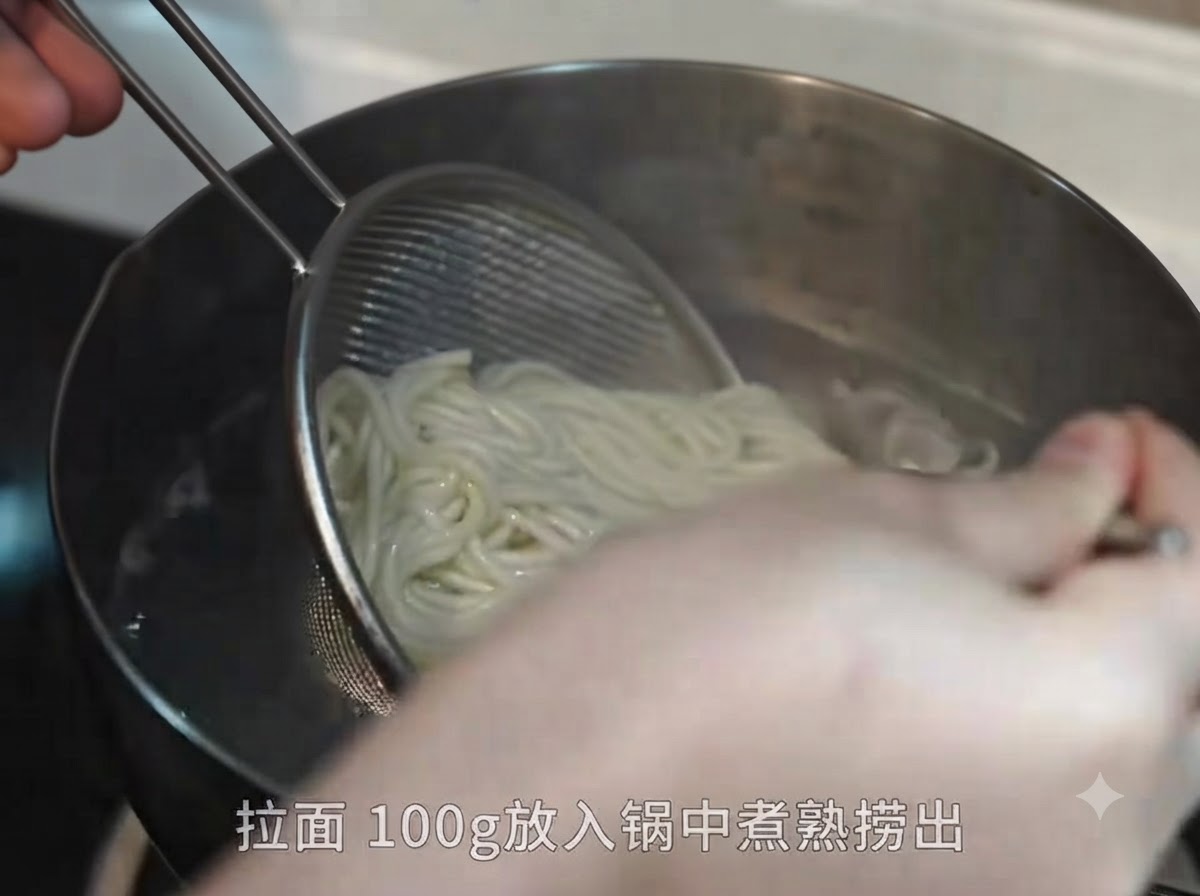 금속 체 망과 젓가락을 이용해 끓는 물에서 삶아진 라멘 면을 건져내는 모습.