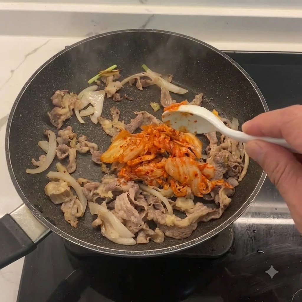 잘게 썬 김치가 소고기와 양파가 있는 팬에 섞이고 있습니다.