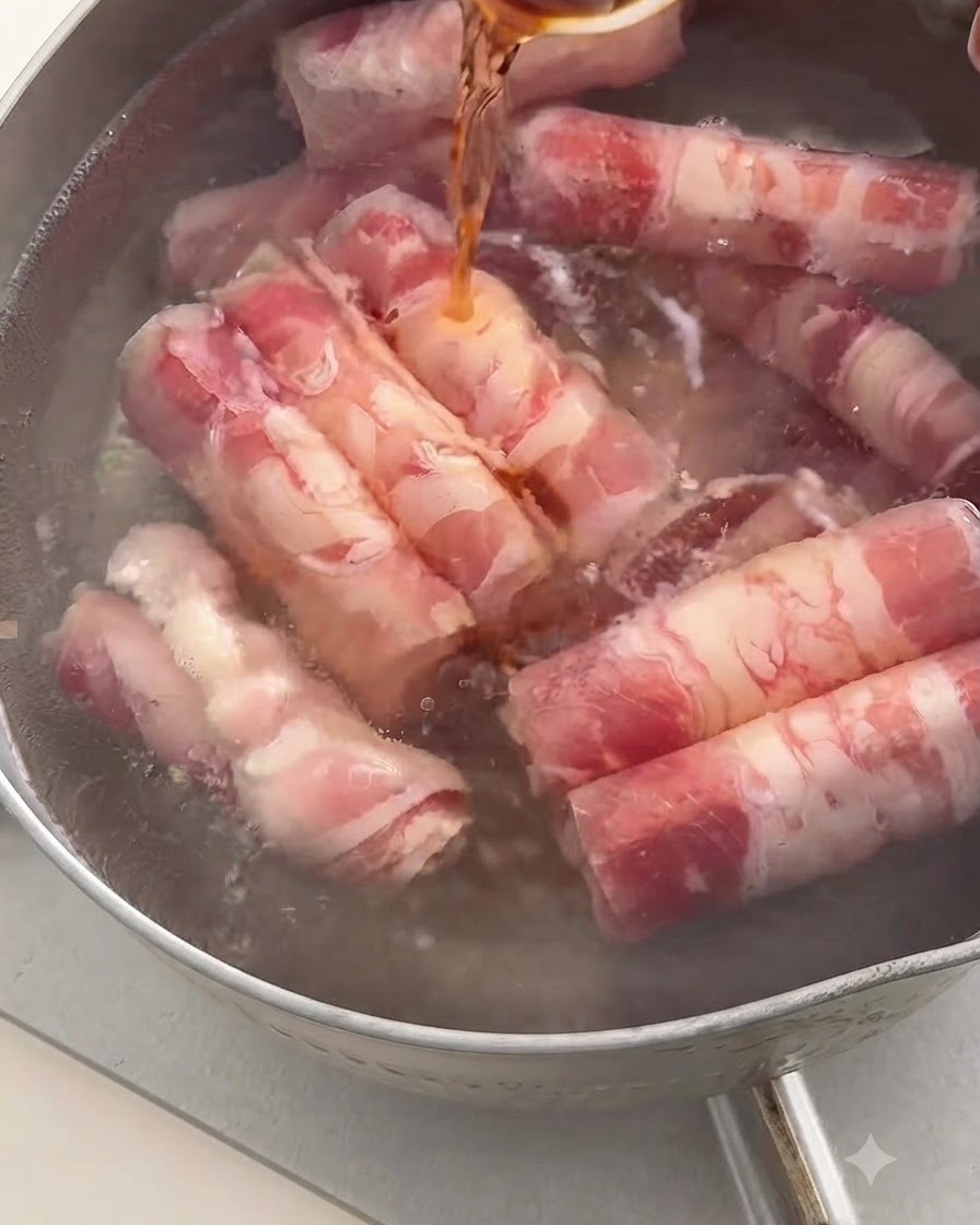 소고기 롤이 들어있는 끓는 물 냄비에 숟가락으로 진한 맛술을 붓는 모습.