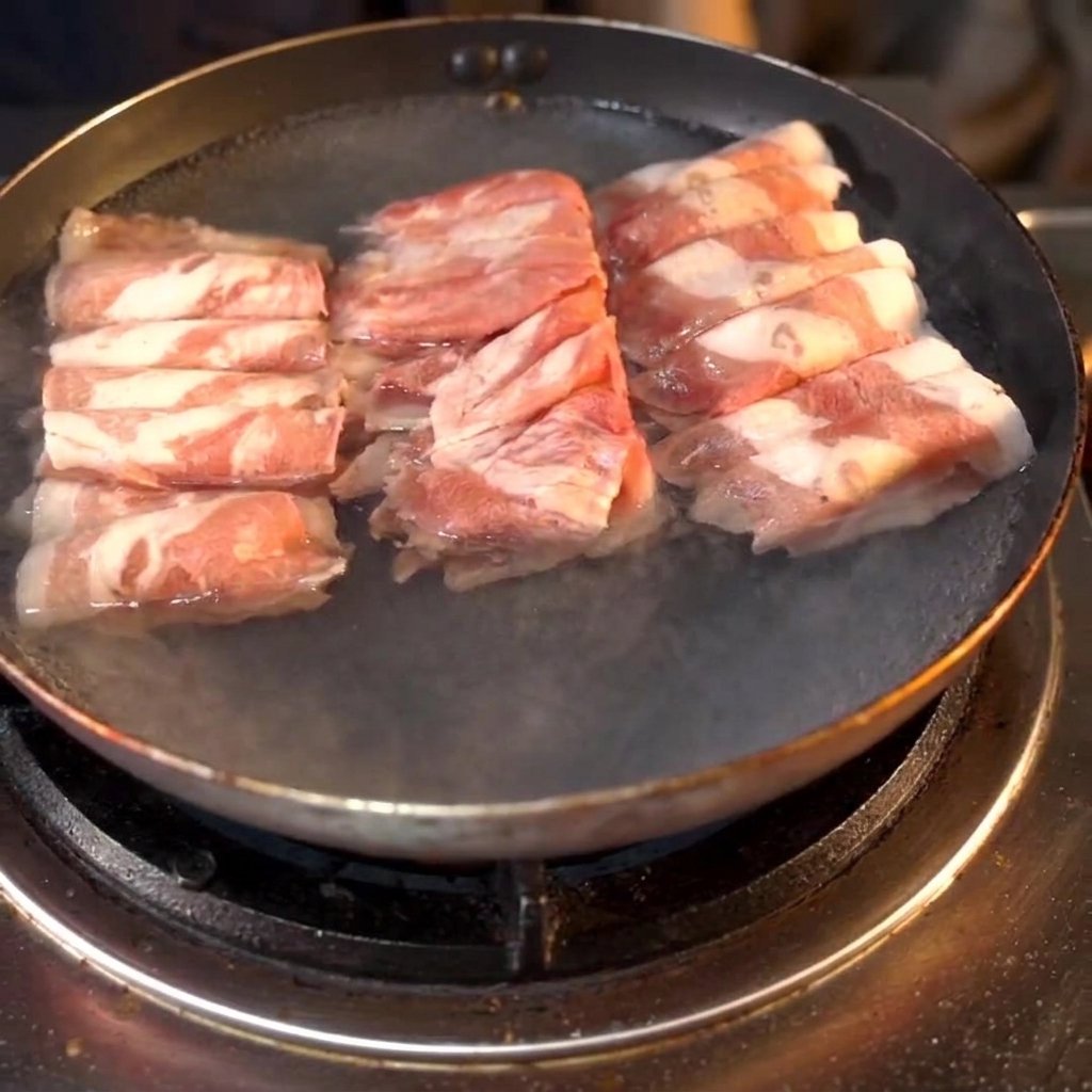 맛술이 추가된 물이 담긴 냄비에서 끓고 있는 소고기 롤.