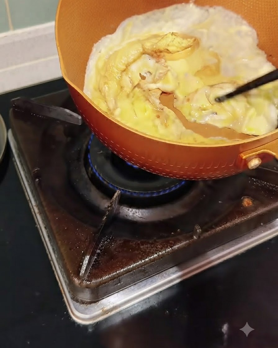 팬에서 요리되는 달걀을 젓가락으로 부드럽게 밀며 스크램블하는 모습