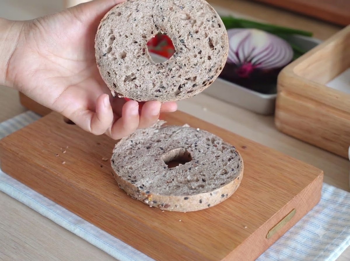 오븐에서 굽는 중인 작은 흰색 카운터톱 오븐 안의 베이글 반쪽 두 개.