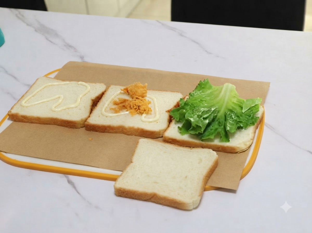 집게를 이용해 드레싱이 발린 식빵 조각 위로 돼지고기 플로스 한 덩이를 옮기는 모습.
