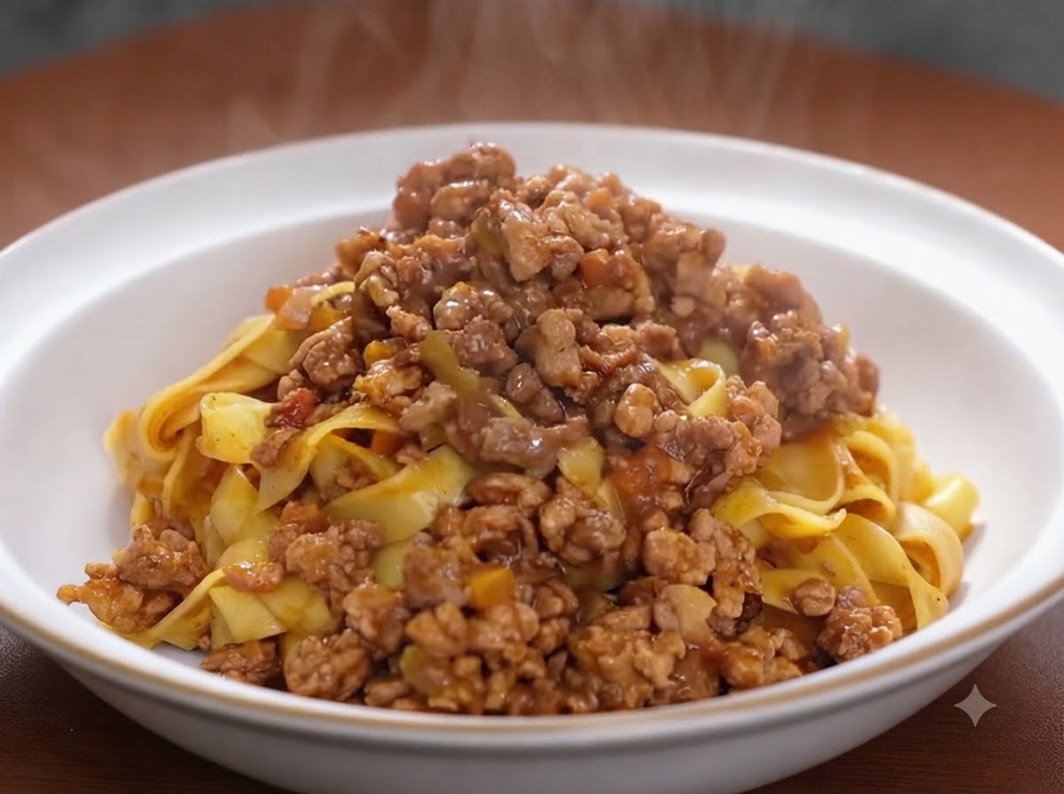 잘 볶아진 고기와 채소 혼합물에 토마토 페이스트를 넣고 섞는 모습.