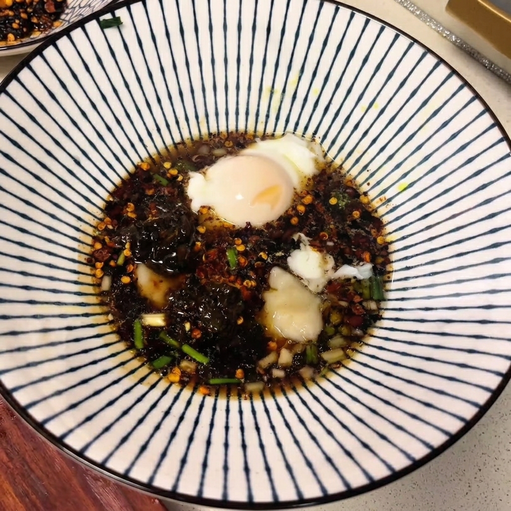 진한 국물, 향신료, 수란이 떠 있는 세라믹 그릇.