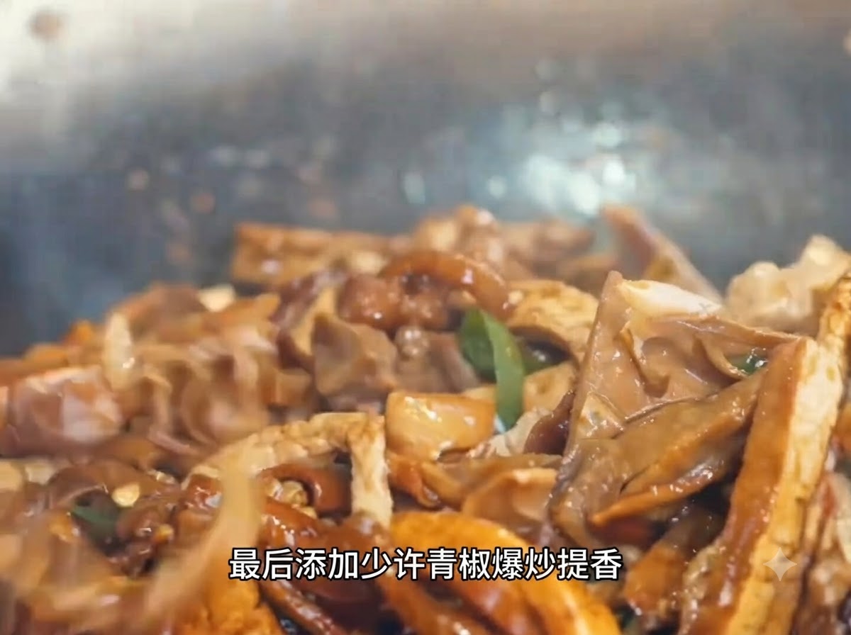 고기와 죽순이 끓고 있는 웍에 썬 청피망을 넣고 섞는 모습.