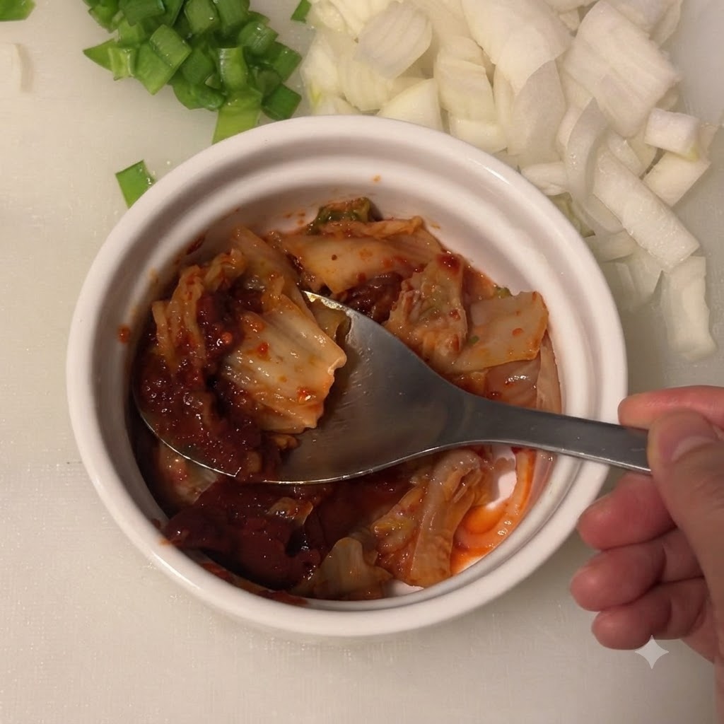 김치와 고추장이 담긴 그릇에 진간장을 붓는 모습.
