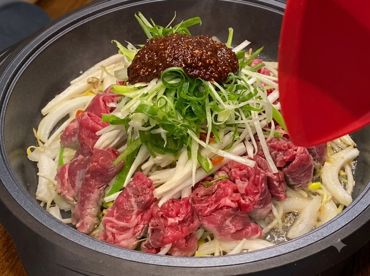 가열된 조리 팬 안에서 재료들이 함께 섞이며 볶아지고 있습니다.