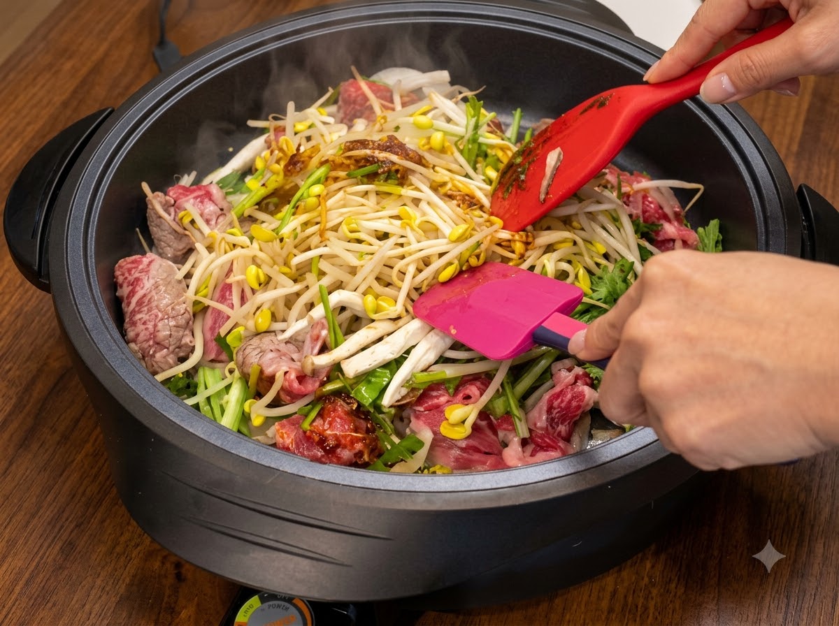 뜨거운 팬 안에서 두 개의 주걱으로 재료를 섞고 볶으며 양념을 더하고 있습니다.