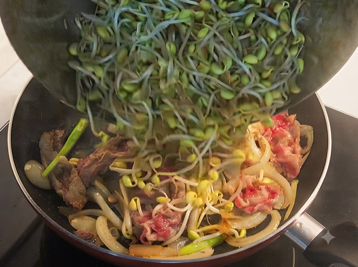 반쯤 익은 우삼겹과 양파 위에 신선한 콩나물을 수북하게 얹는 모습.