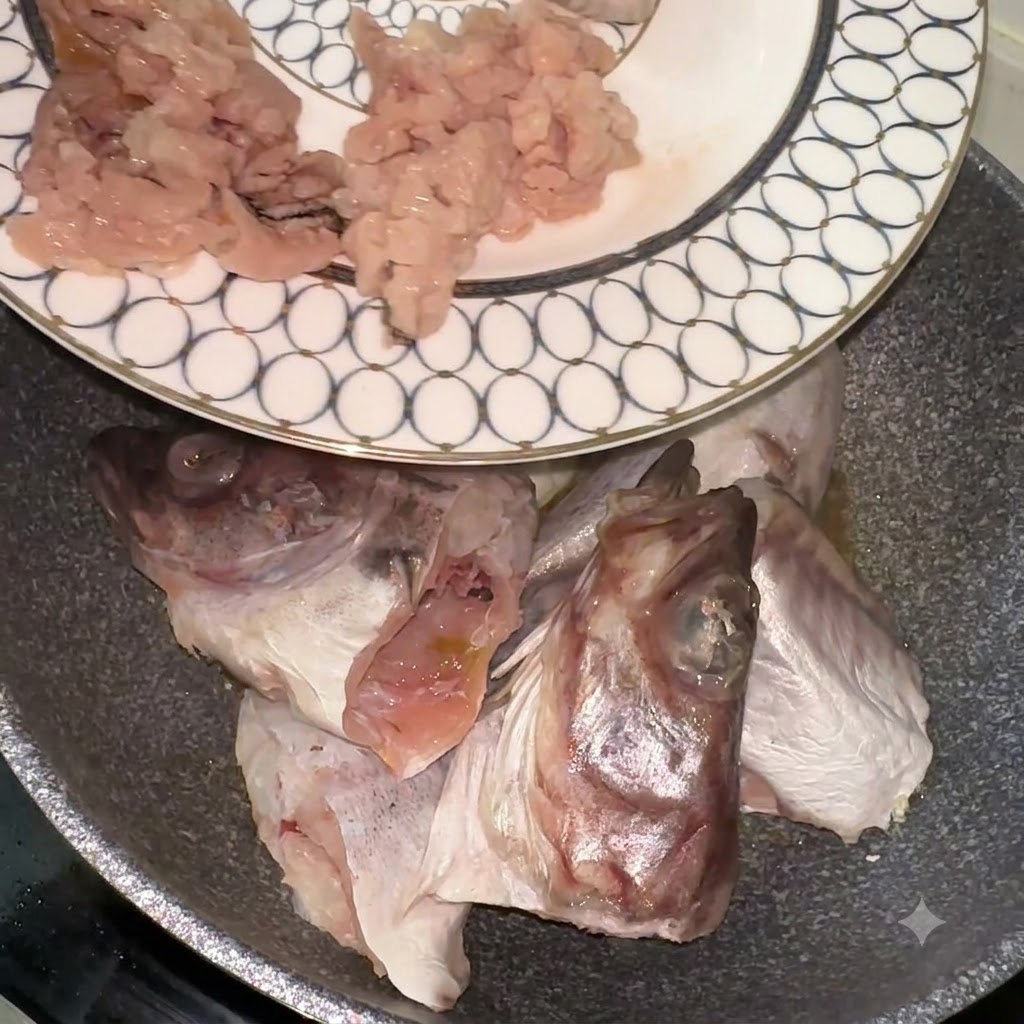 무늬가 있는 접시에 담긴 신선한 동태 토막과 대가리를 팬으로 옮기는 모습