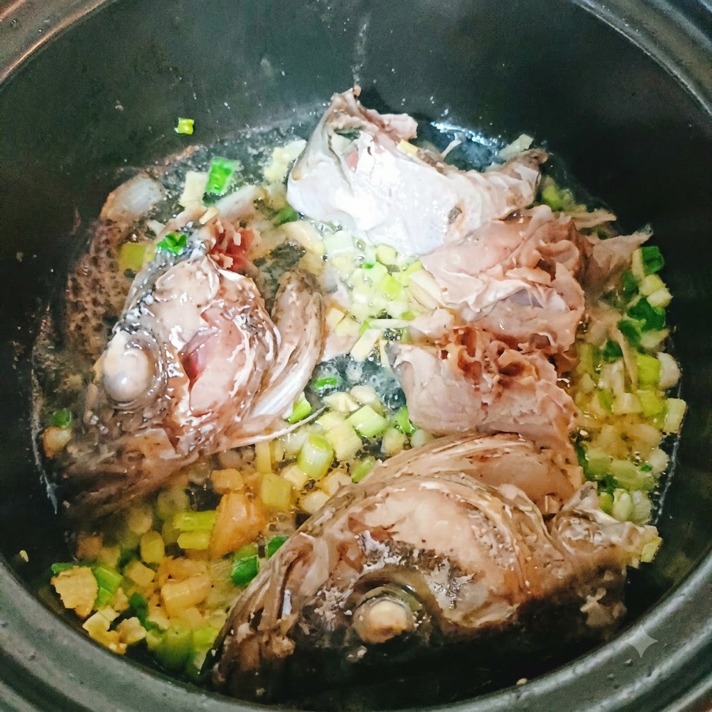 다진 향채소와 함께 냄비에서 볶아지고 있는 명태 조각과 머리