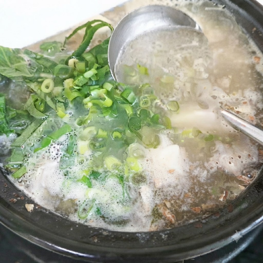 완성된 국 냄비 위에 신선한 깻잎과 다진 대파를 올리는 모습