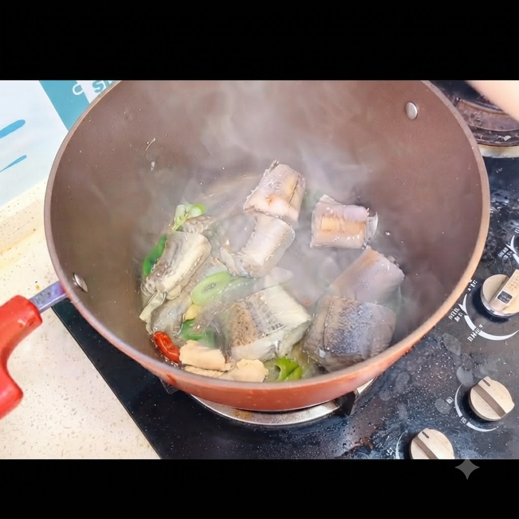 스토브 위의 냄비에 담긴 생선 조각 위로 끓는 물을 붓는 모습.