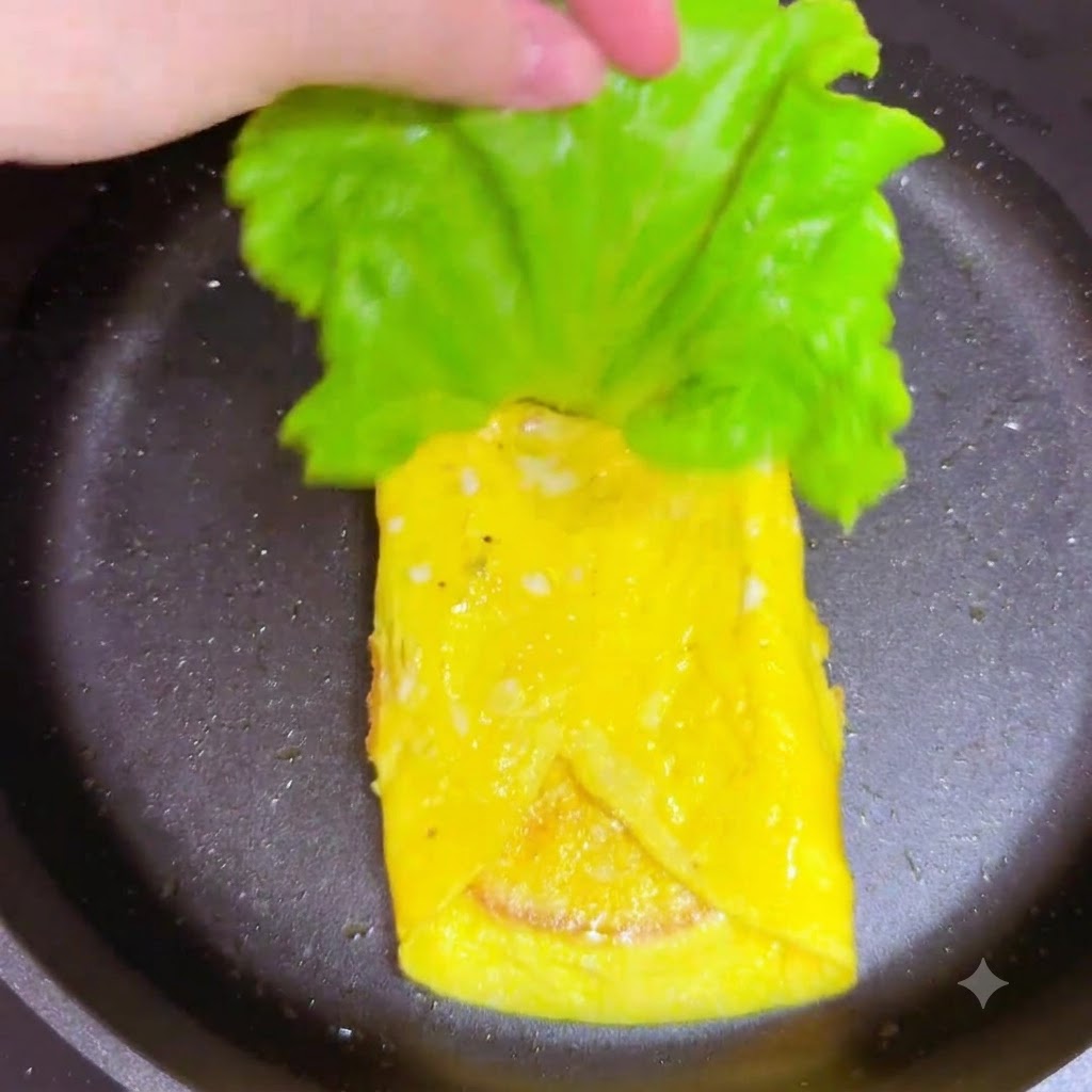 팬 안의 햄 층 위에 신선한 초록색 상추 잎을 올리는 모습.