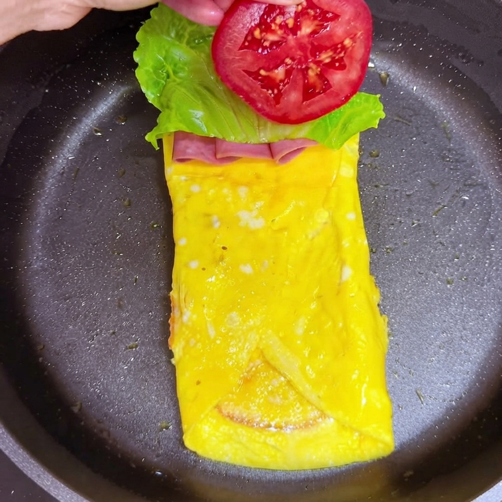 상추 잎 층 위에 빨간 토마토 조각을 올리는 모습.