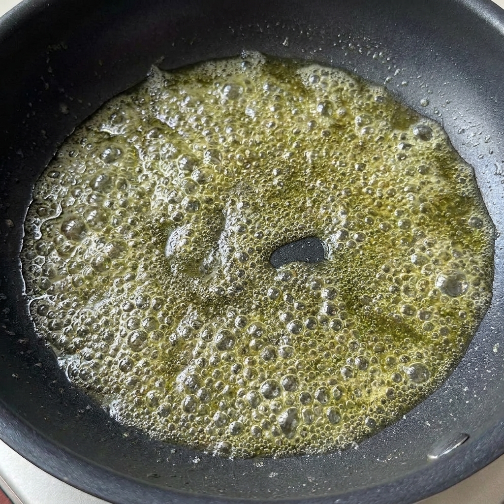 팬 안에서 녹아 거품이 이는 버터에 진간장과 토마토 페이스트가 추가된 모습.