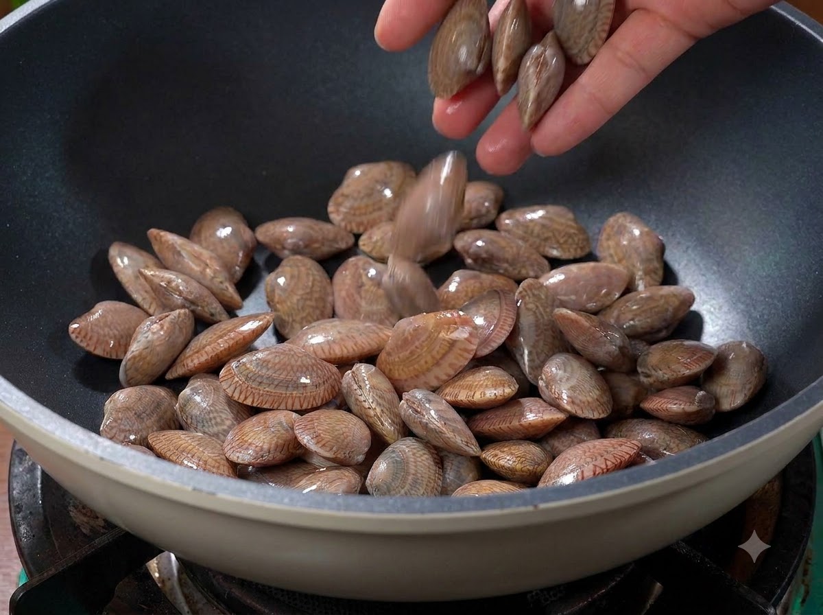 뜨겁게 달궈진 마른 웍에 넣어져 볶아지는 조개.
