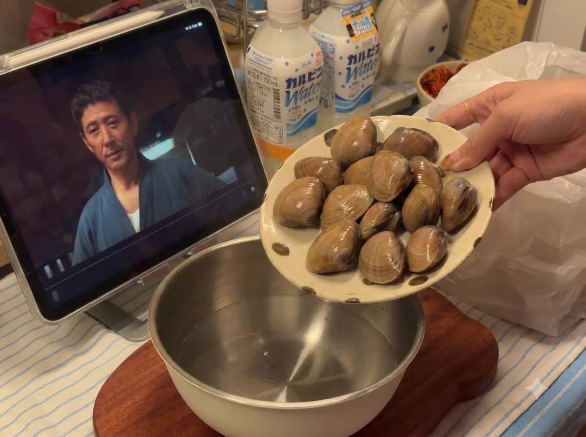 물이 담긴 금속 그릇에 접시에서 신선한 조개가 부어지는 모습.