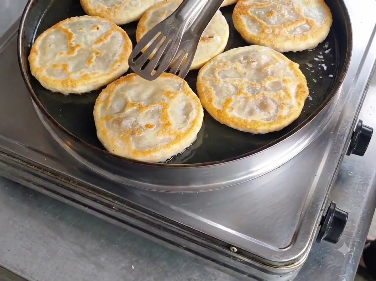 프라이팬에서 집게로 꺼내기 전 양면이 노릇하고 바삭하게 잘 익었는지 확인하는 모습.