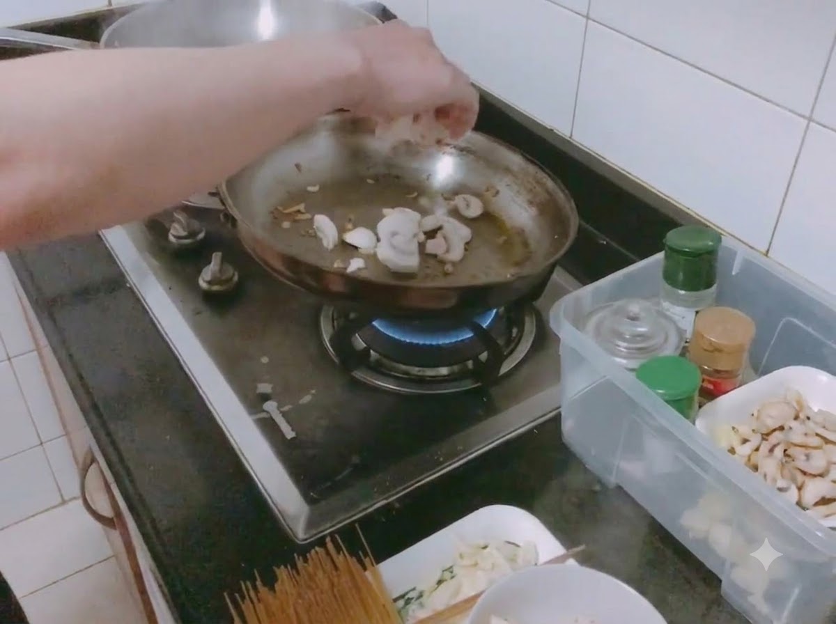 얇게 썬 양송이버섯과 다진 양파를 소금과 함께 프라이팬에 볶는 모습.