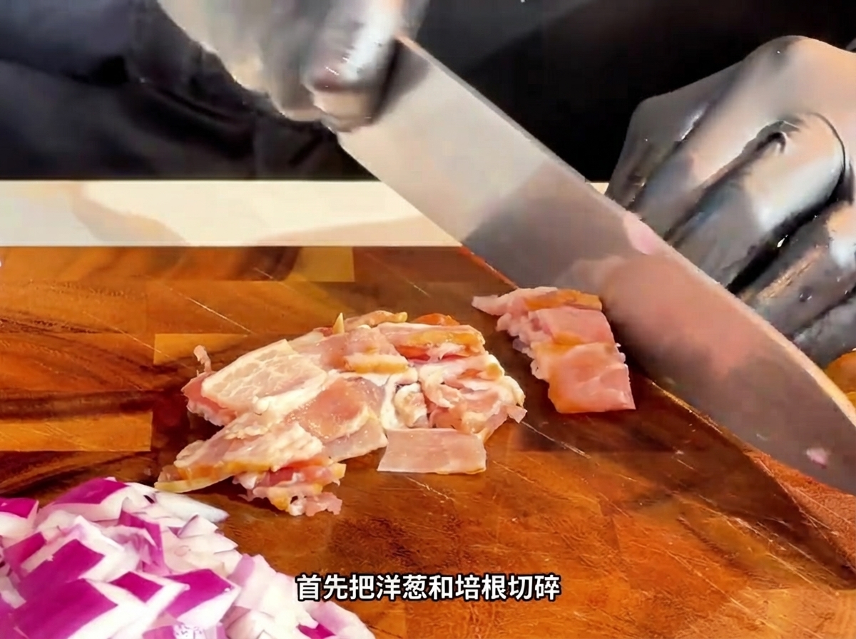 나무 도마 위에서 칼로 생 베이컨을 작은 조각으로 썰고 있는 모습.